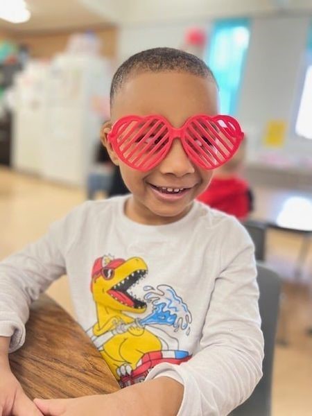 Child wearing heart shaped glasses