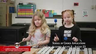 Two young girls play the xylophone